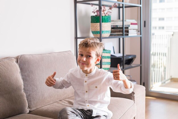 Photo portrait of boy sitting on sofa at home