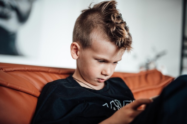 Portrait of boy sitting on sofa at home