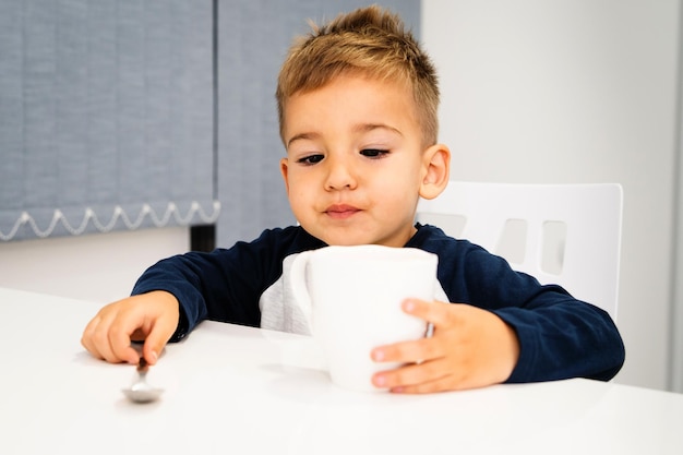 家のテーブルに座っている男の子の肖像画