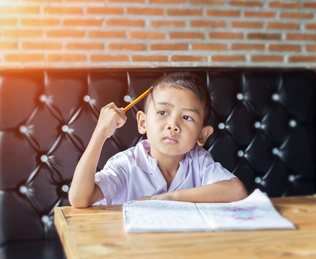 Photo portrait of boy sitting on table