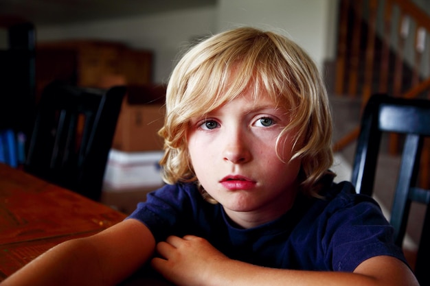 Photo portrait of boy sitting at table