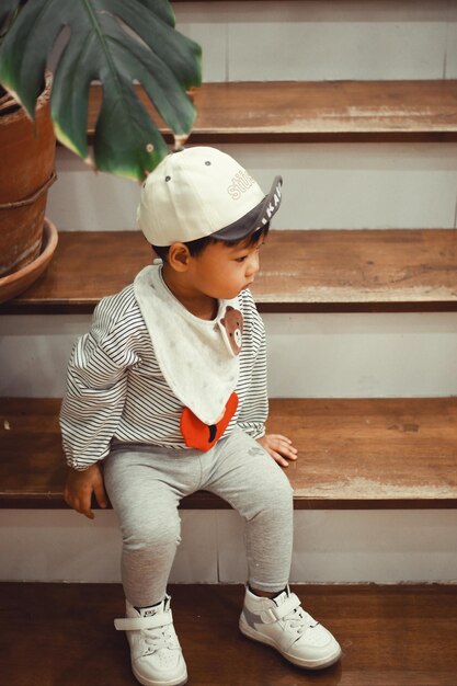 Photo portrait of boy sitting on wooden bench