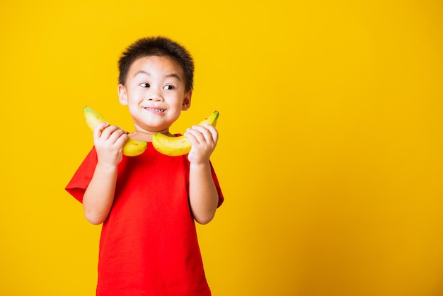 Photo portrait of boy standing against yellow background