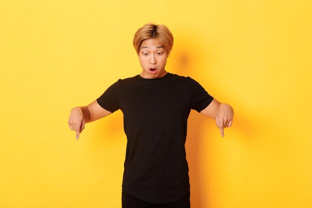 Portrait of boy standing against yellow background