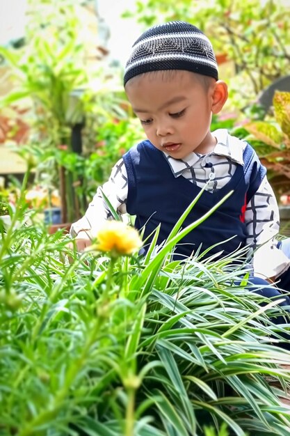 Portrait of boy standing amidst plants