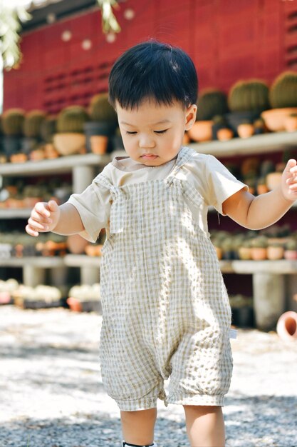 Portrait of boy standing on footpath