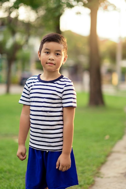 Portrait of boy standing at public park