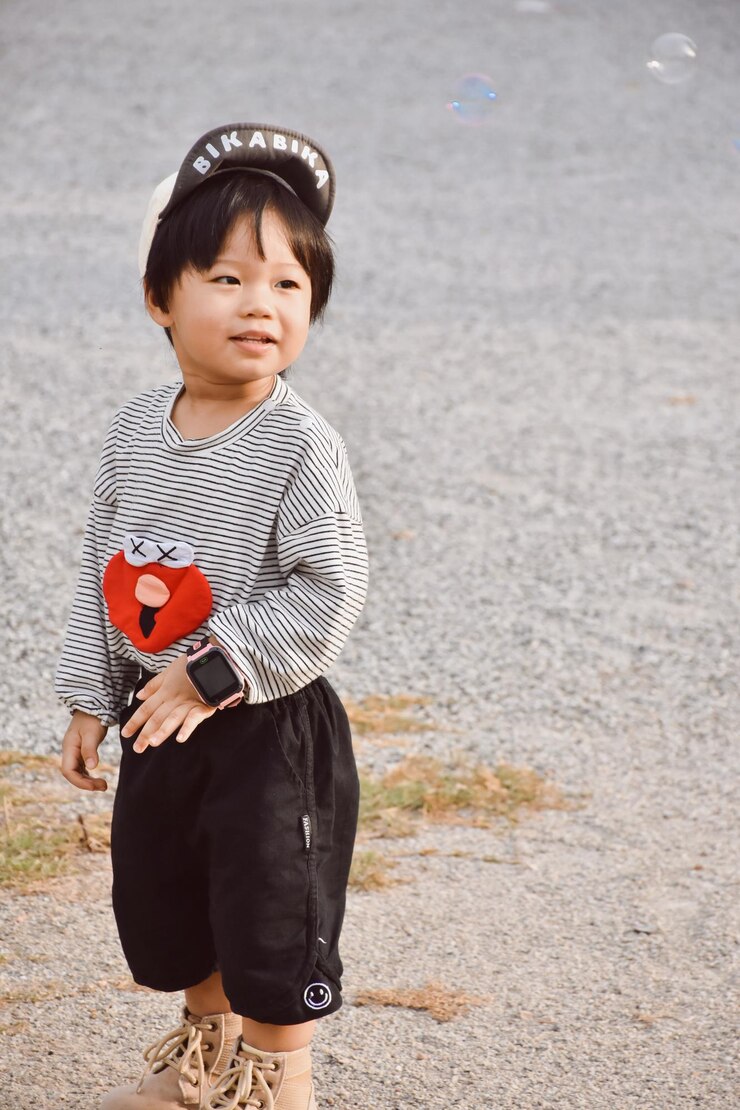 Photo 浜辺の砂の上に立っている少年
