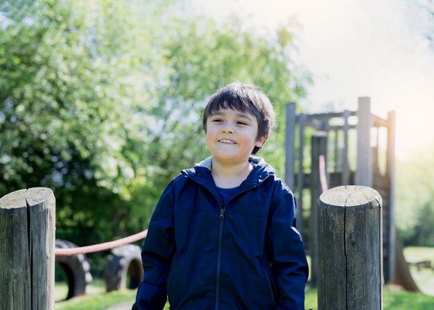 Photo portrait of boy standing on wooden post