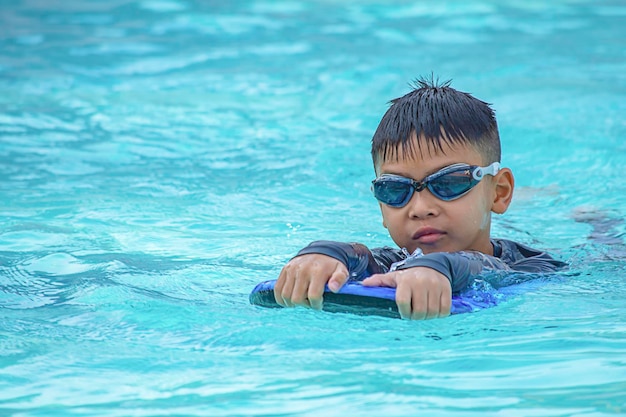 Photo portrait of boy swimming in pool