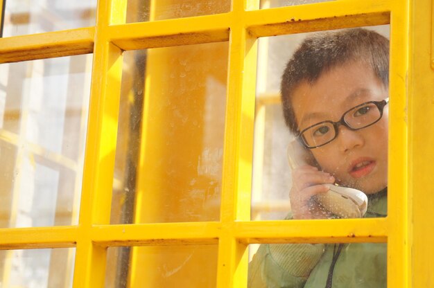 Portrait of boy talking on phone in both