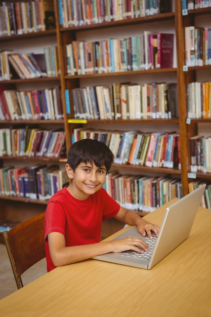 Portrait of boy using laptop in library