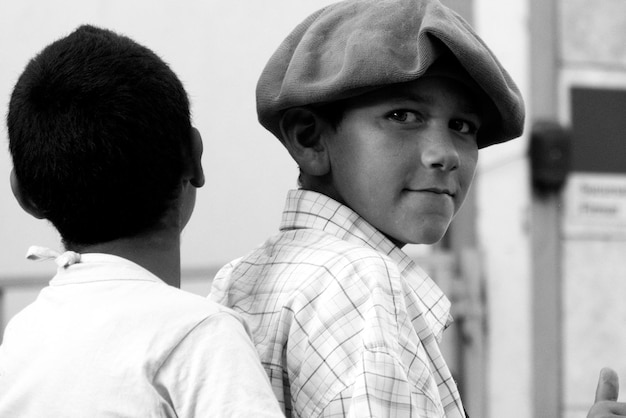 Photo portrait of boy wearing hat by friend outdoors