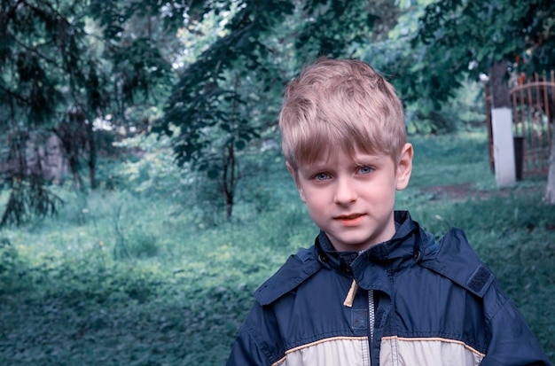 portrait of boy wearing raincoat in forest