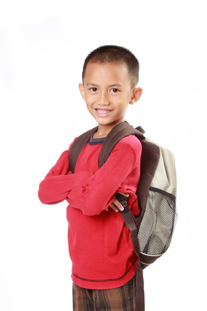 Portrait of boy with backpack smiling against white