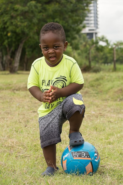 Portrait of boy with ball standing on field