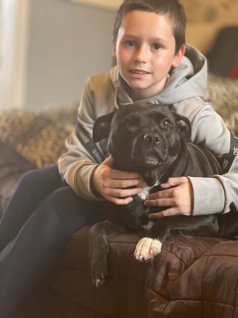 Photo portrait of boy with dog at home