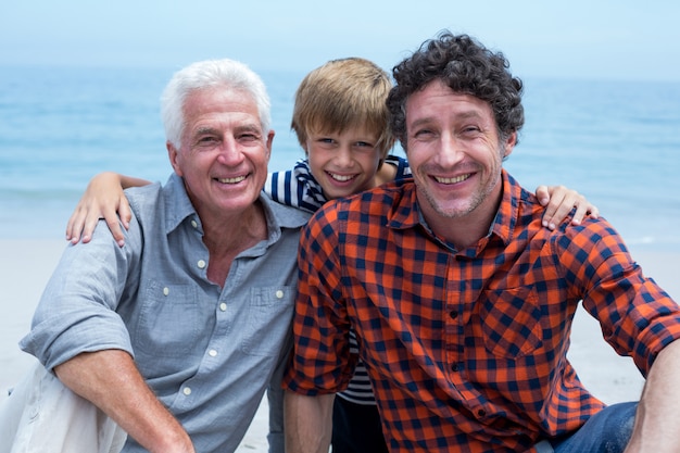 Photo portrait of boy with father and grandfather beach