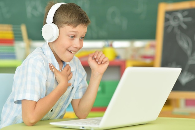 Portrait of boy with headphones using laptop