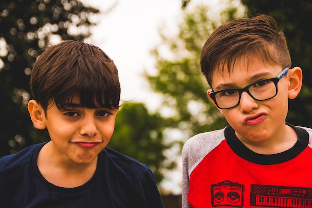 Foto ritratto di ragazzi che fanno la faccia all'aperto