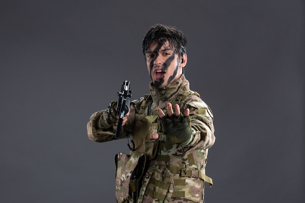 어두운 벽에 기관총으로 위장한 용감한 군인의 초상화
