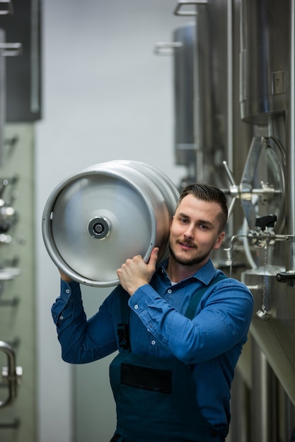 Portrait of brewer carrying keg