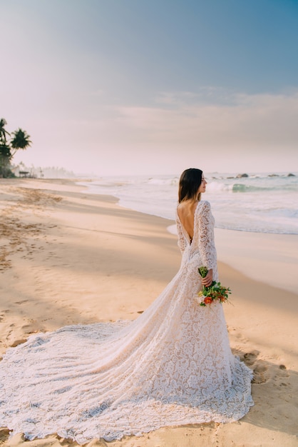 Portrait of bride in full growth on tropical beach