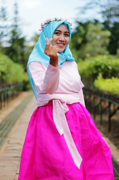 Portrait of bride gesturing while standing at park