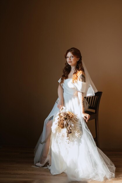 Portrait of a bride girl with red hair in a white wedding dress