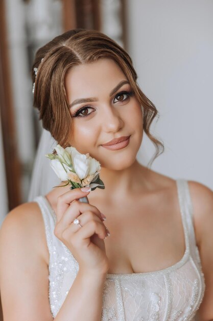 Portrait of the bride in the hotel room A beautiful young girl is dressed in a white wedding dress Modern wedding hairstyle Natural makeup