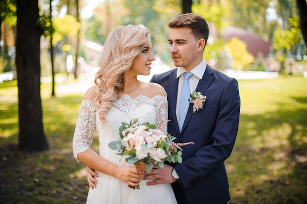 Portrait of a bridegroom embracing a blonde bride