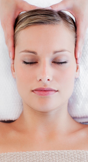 Portrait of a bright young woman receiving a head massage