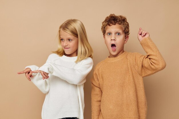 Photo portrait of brother with sister against beige background