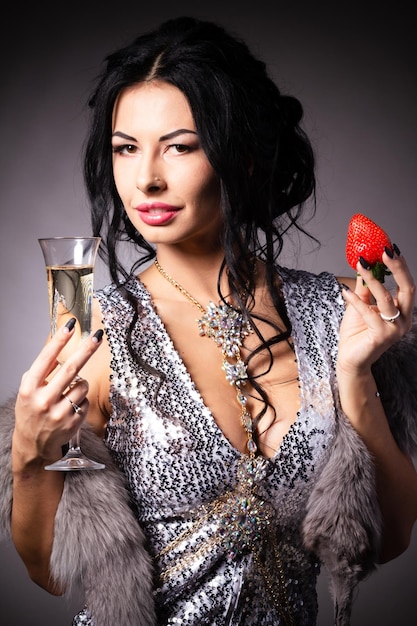 Portrait of a brunette beauty with honey dripping strawberry