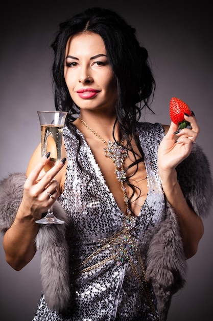 Portrait of a brunette beauty with honey dripping strawberry