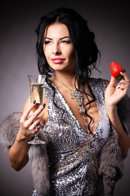 Portrait of a brunette beauty with honey dripping strawberry