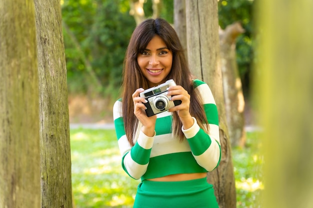 Portrait of a brunette caucasian girl on vacation in nature taking photos with the camera