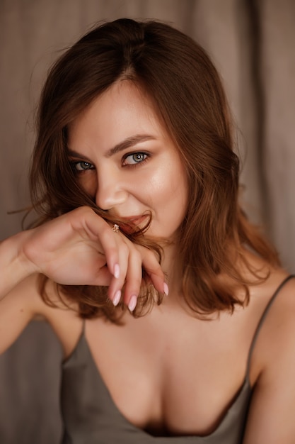 Portrait of a brunette girl on a fabric brown background