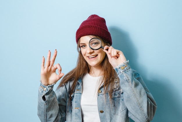 Portrait of a brunette girl holding a magnifying glass