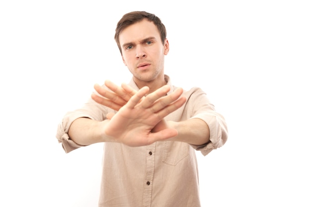 Portrait of brunette man in casual showing stop gesture, no please, you are refused isolated on white