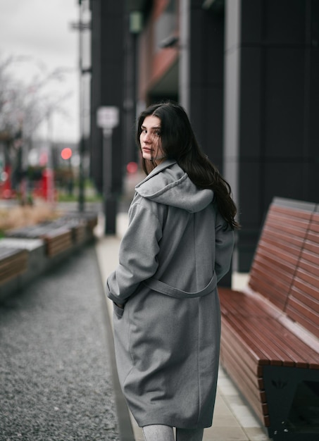 Portrait of brunette woman in the business downtown of modern city Girl with long hair turn around and looking in camera Business woman with trafic city lights in the background