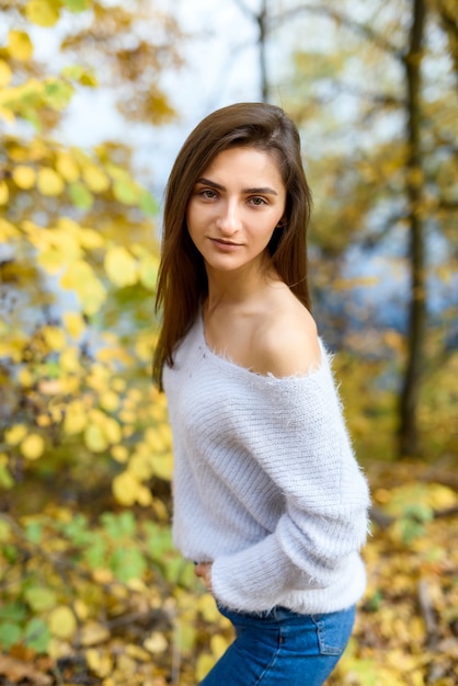 Portrait of brunette woman in casual wear in autumn park