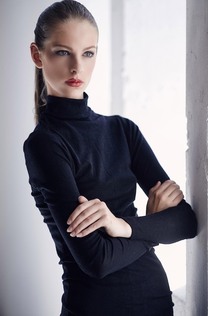 Portrait of brunette woman with crossed arms in black costume.