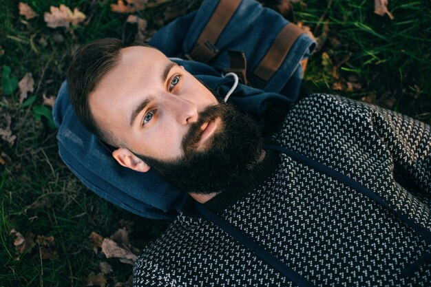 Portrait brutal bearded hipster dreamer man in the forest	