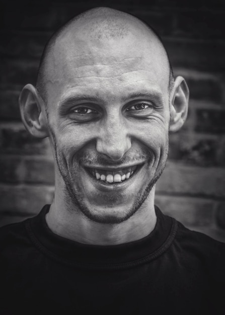 Portrait of a brutal young man with a smile on his face in black and white