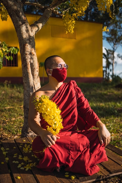 Portrait of a Buddhist monk holding flowers