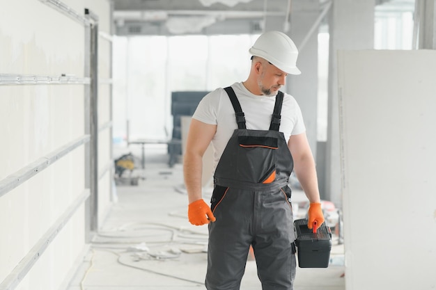 Portrait of a builder in the process of working on a construction site indoors