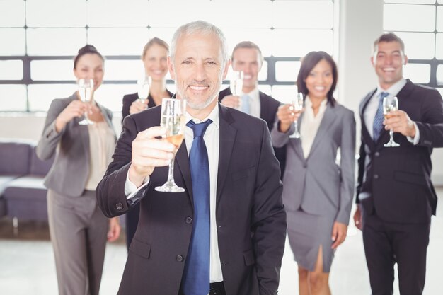 Portrait of business man holding champagne flute