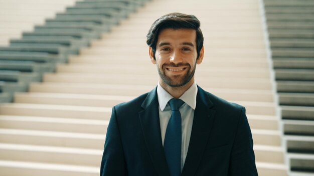 Portrait of business man looking at camera while standing at stairs Exultant