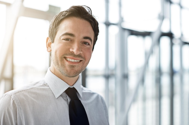 Portrait business and man with a smile lobby and consultant with confidence occupation and career Face male person and employee in a hallway happiness and professional with startup success